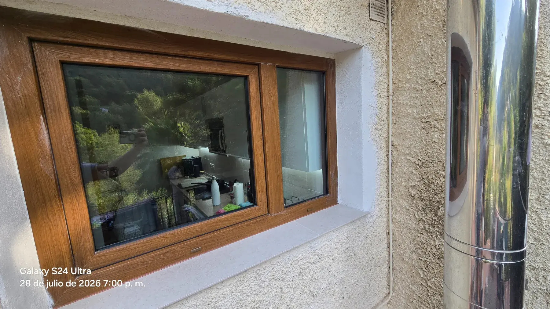 Dos ventanas de PVC acabado madera instaladas en fachada